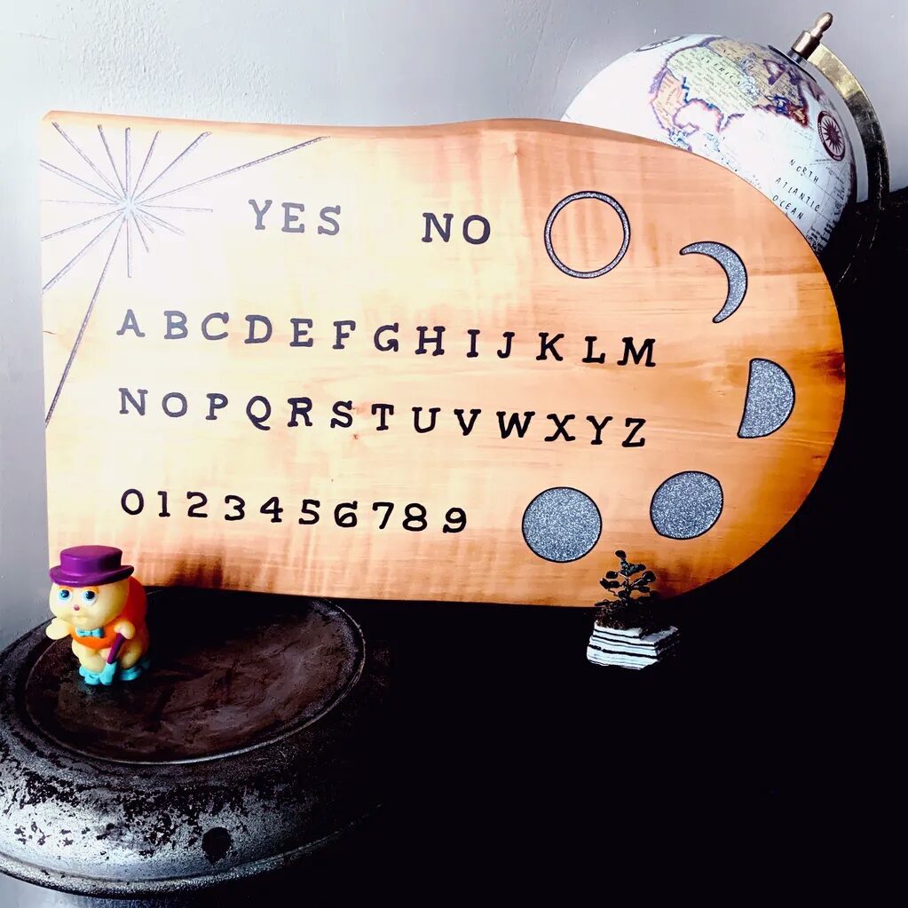 Handmade alphabet board with one side square and the other side rounded. Phases of the Moon are expressed on the rounded side of the board.