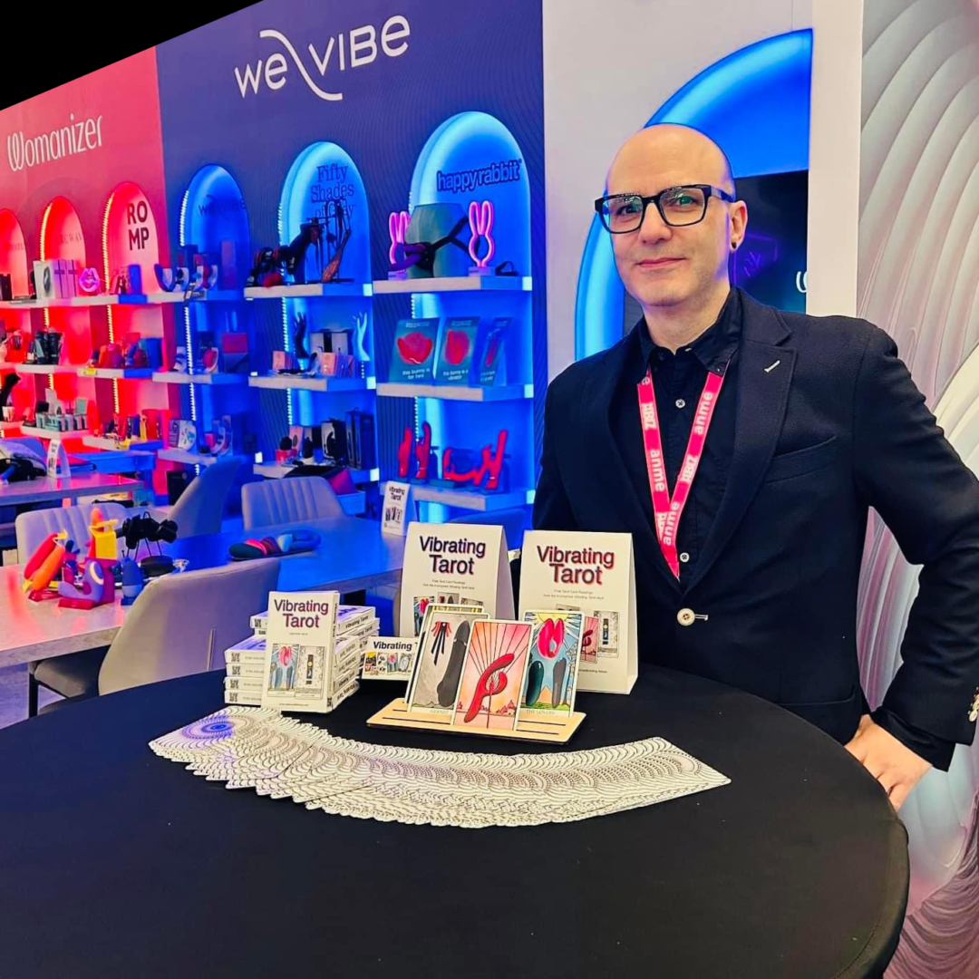 A photo of Frank Lawrence standing in front of the Vibrating Tarot table at the Lovehoney Group booth at the Adult Novelty Manufacturers Expo (ANME) in Burbank, California, in January 2024.